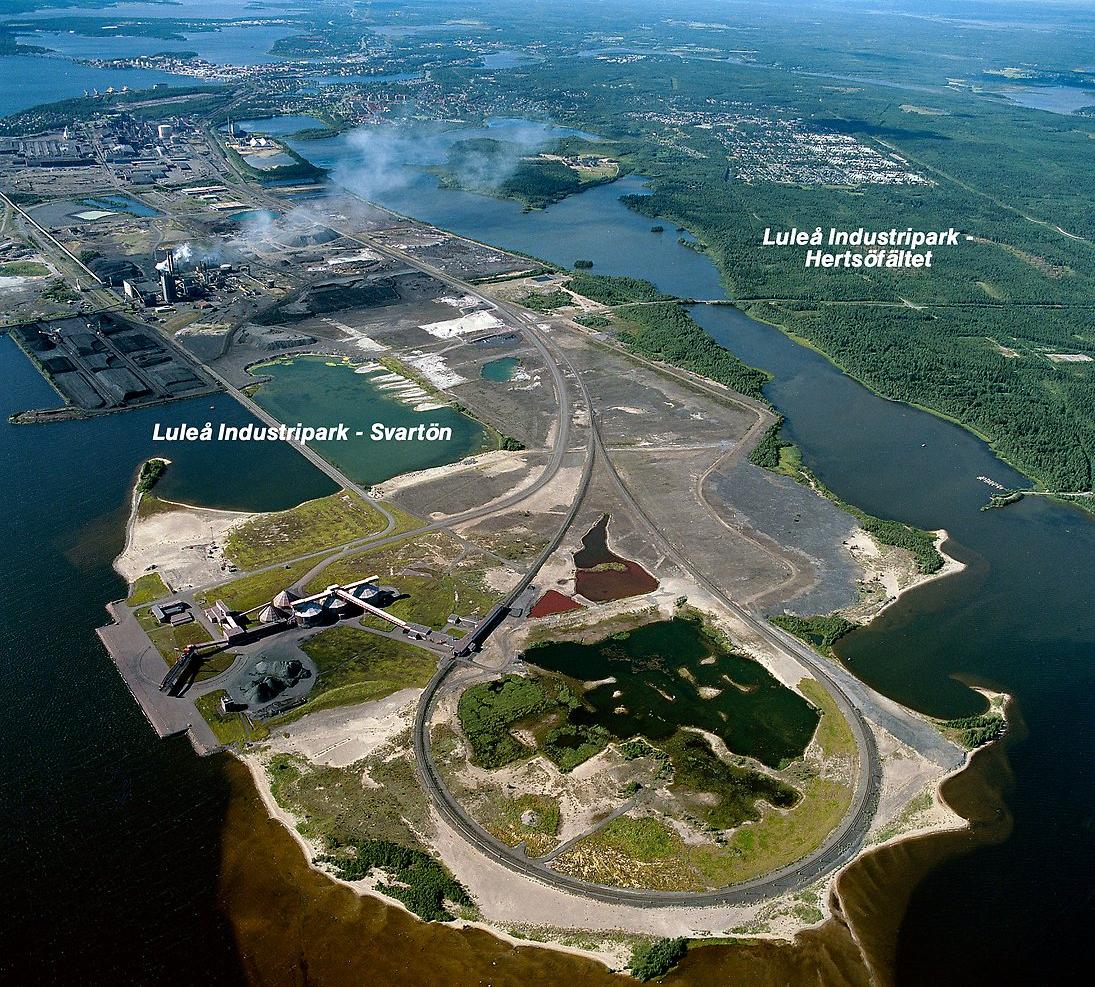 Flygbild som visar Svartön och Hertsöfältet från ovan. På bilden ses Luleå Indistripark från luften med Luleå centrum i fjärran. Till höger i bild ligger det grönområde som är Hertsöfältet där nya industri- och företagsetableringar ska anläggas. Foto: Luleå Hamn