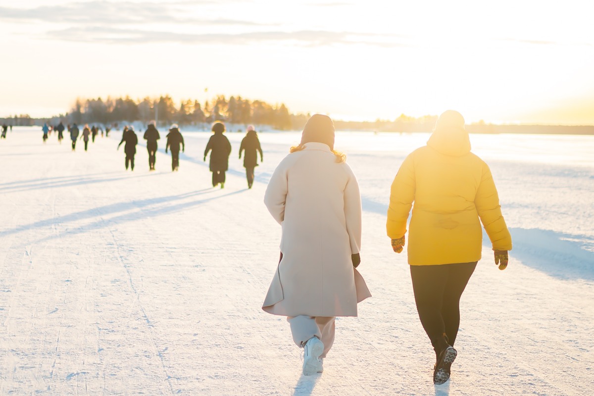 Människor i vinterkläder går över en isväg.